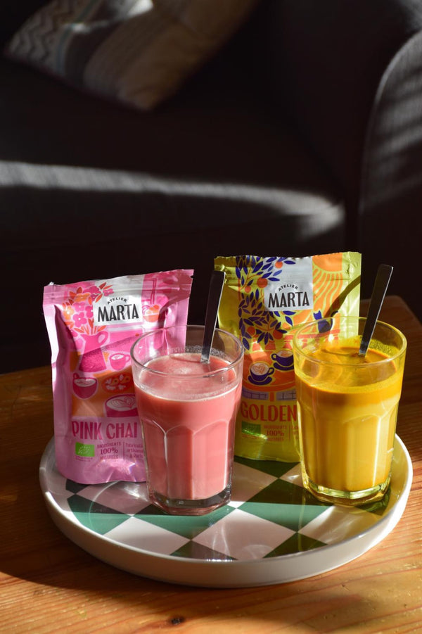 Verres de Pink et de Golden Latte devant leurs sachets